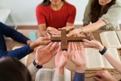 Religious people with faith touching a cross